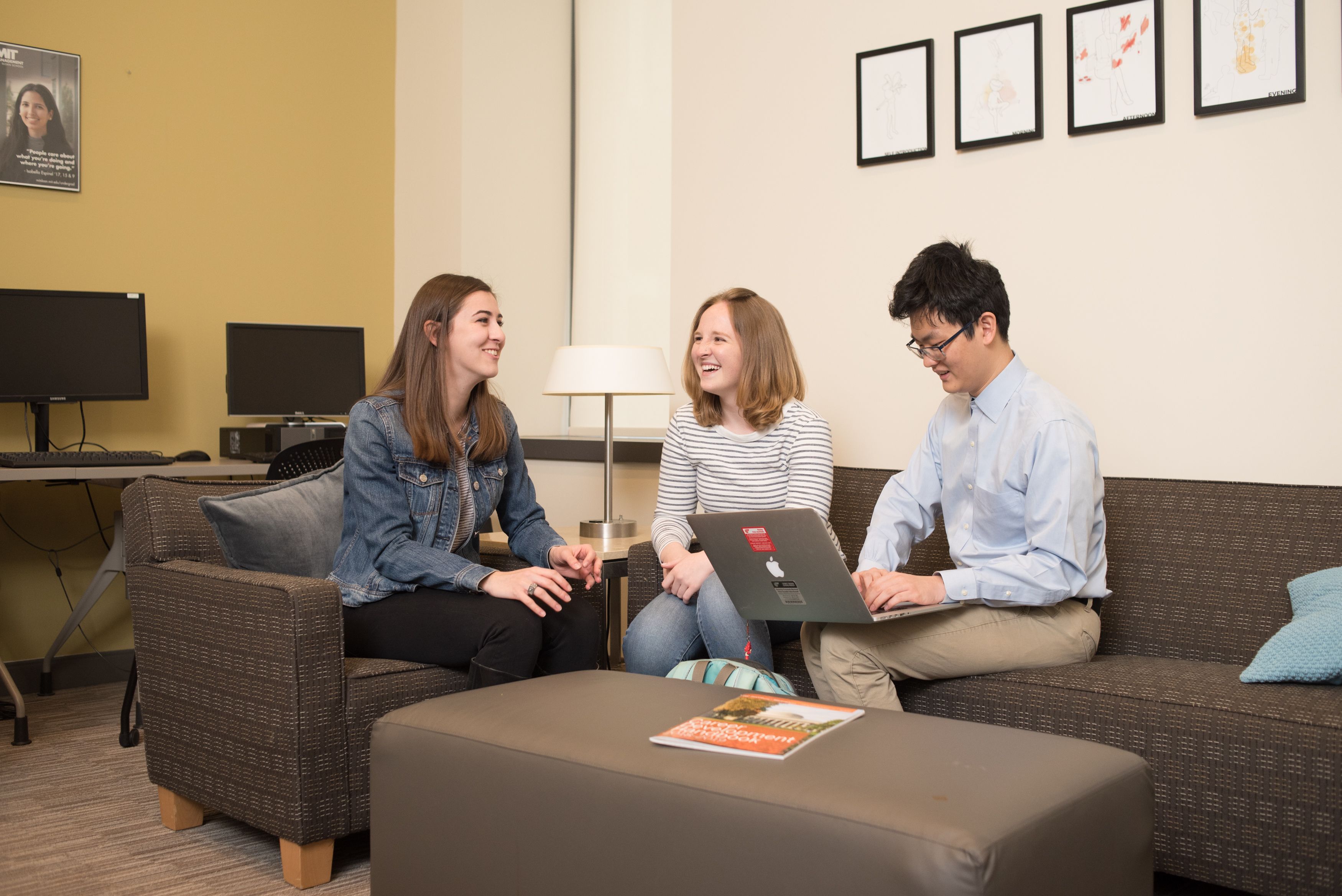 Three undergraduate students work together over a computer