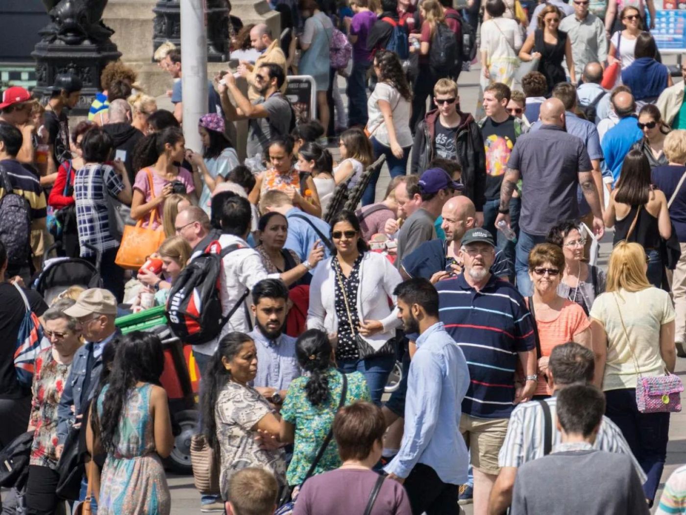 Large crowd of people walking on the street on a sunny day