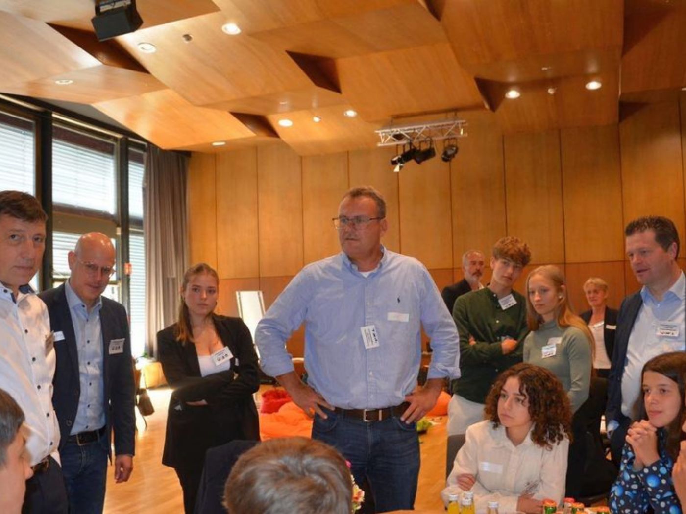 Students and representatives from business and politics stand and sit together, recreating a world climate conference together.