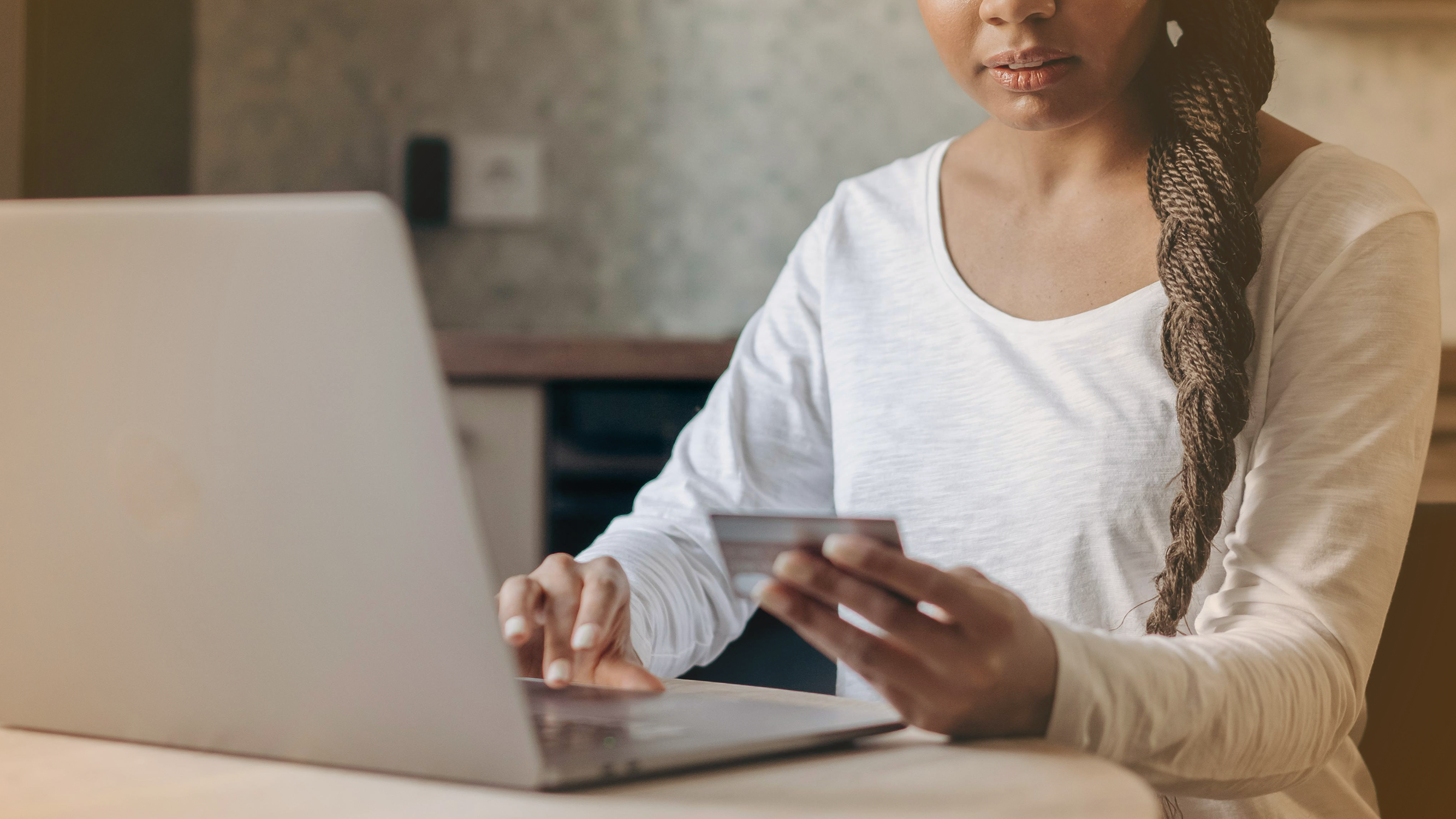 Woman shopping online with a computer and credit card, relating to retirement savings