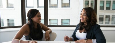 Two women converse at a table