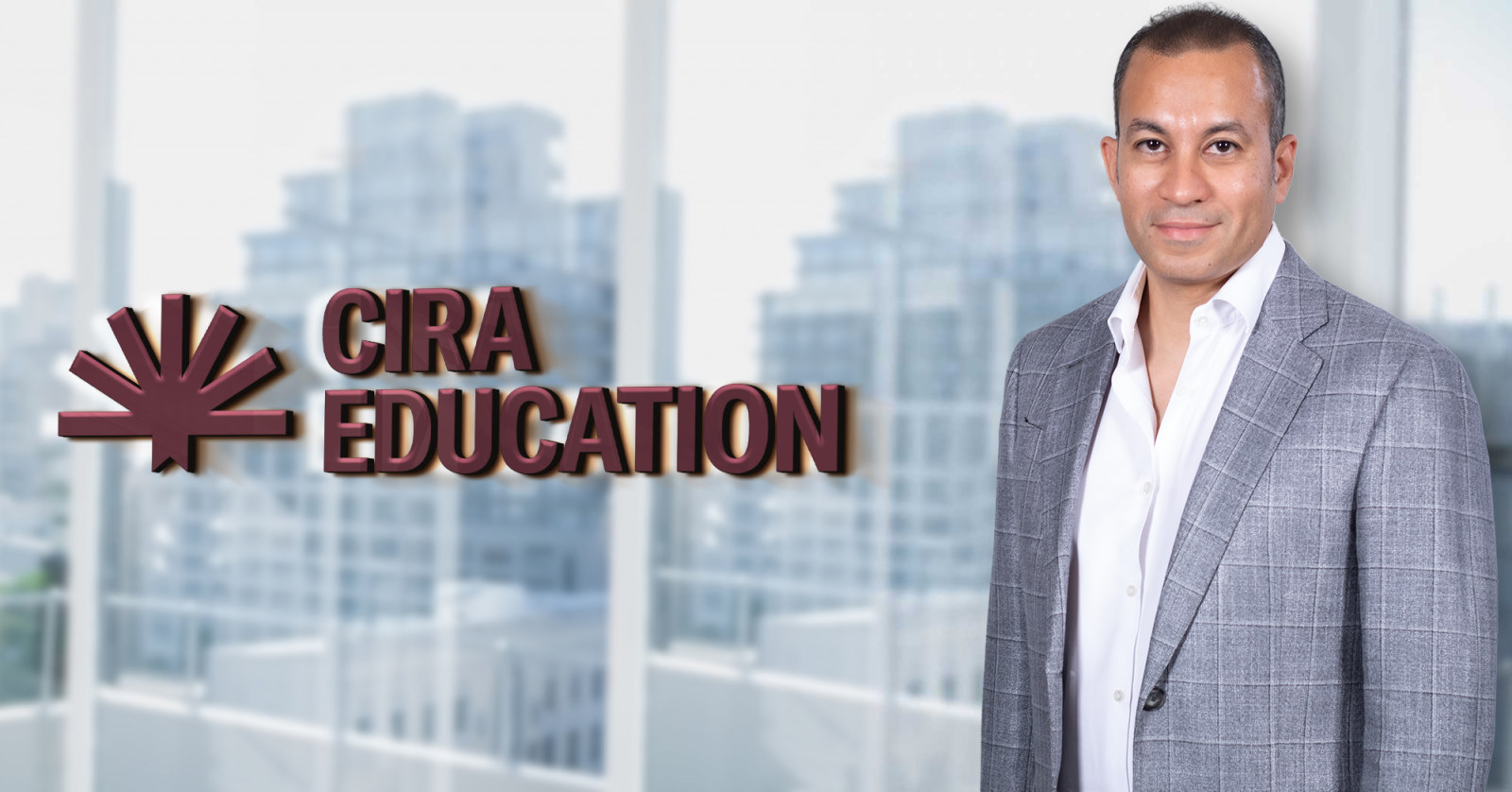 Man in casual suit standing infront of office window that reads "CIRA Education"