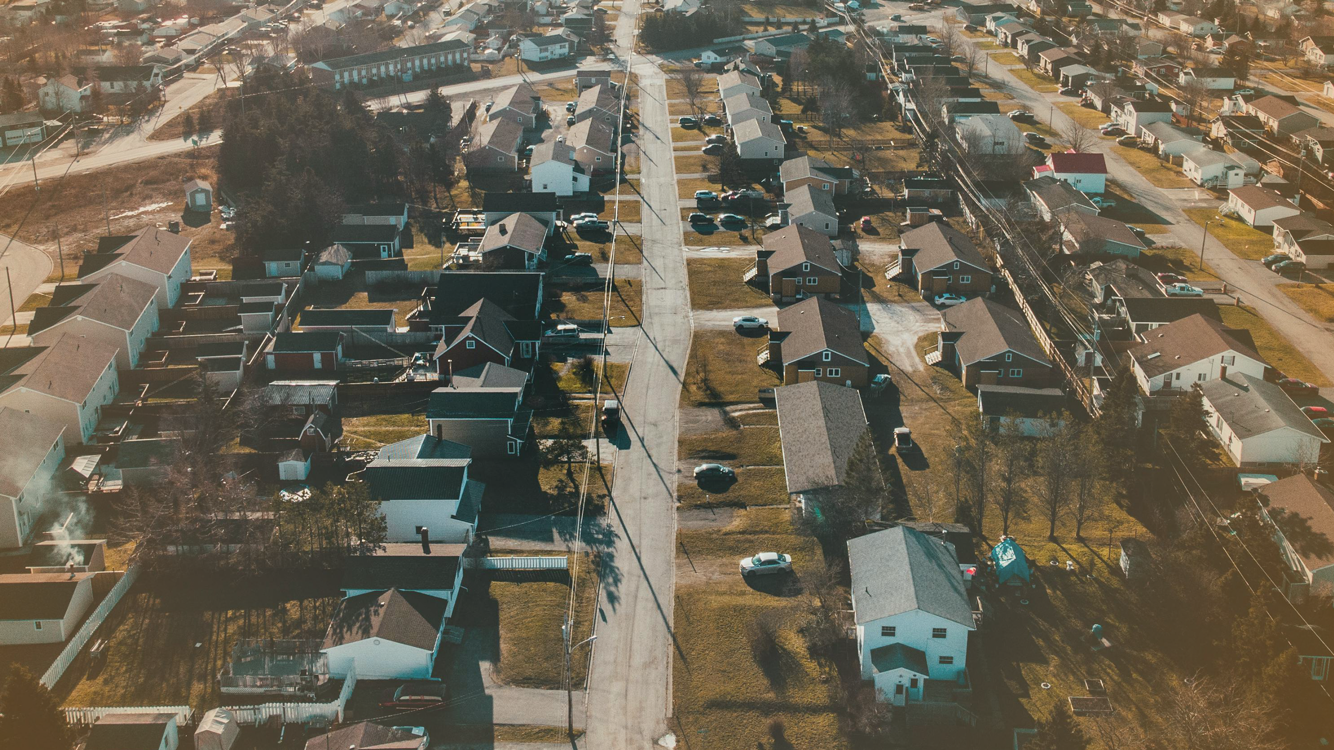 Aerial photograph of houses in suburban neighborhood, connected to mortgage refinancing.