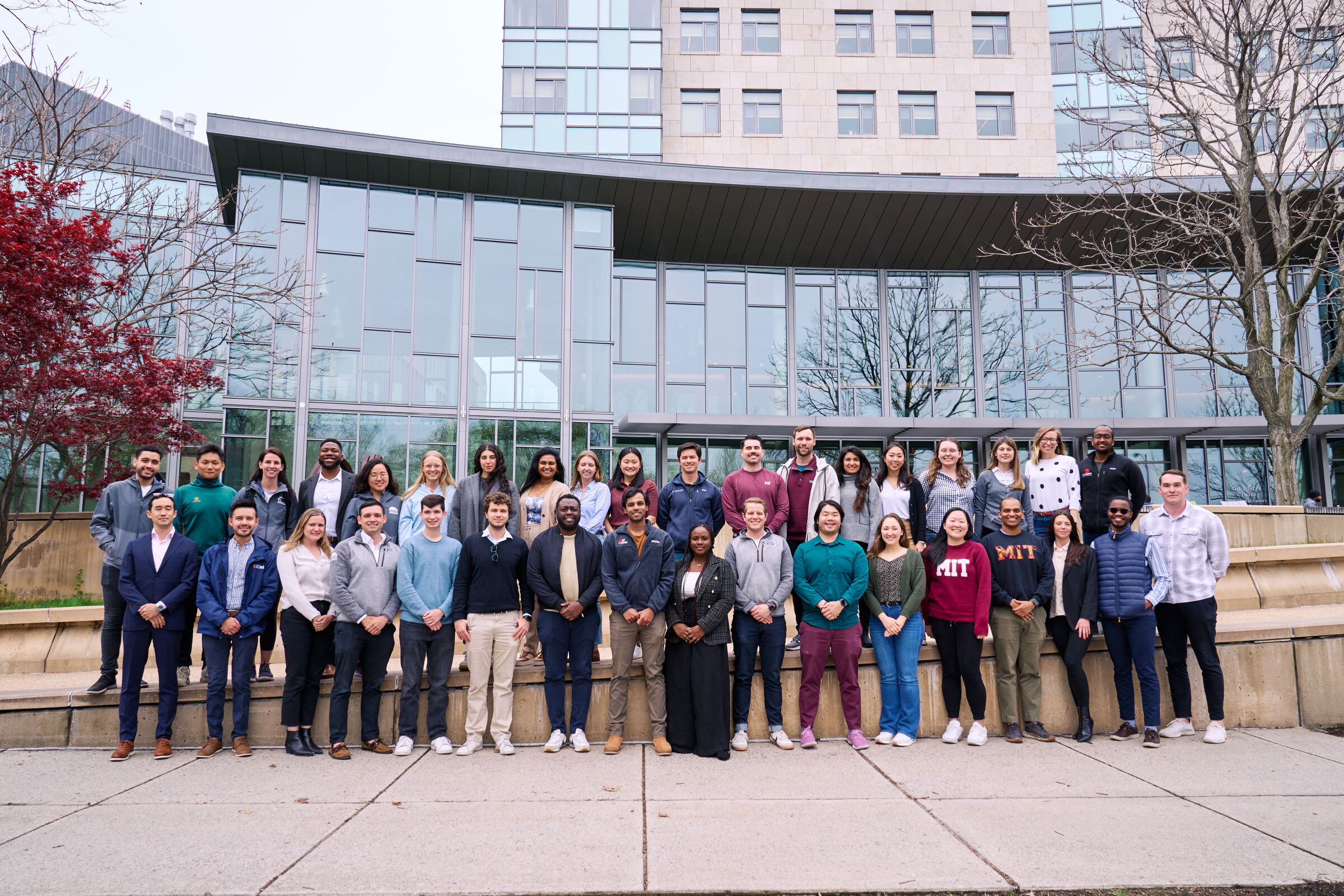 several students who represent the MIT Sloan Student Senate photographed outside MIT Sloan on an early spring day.