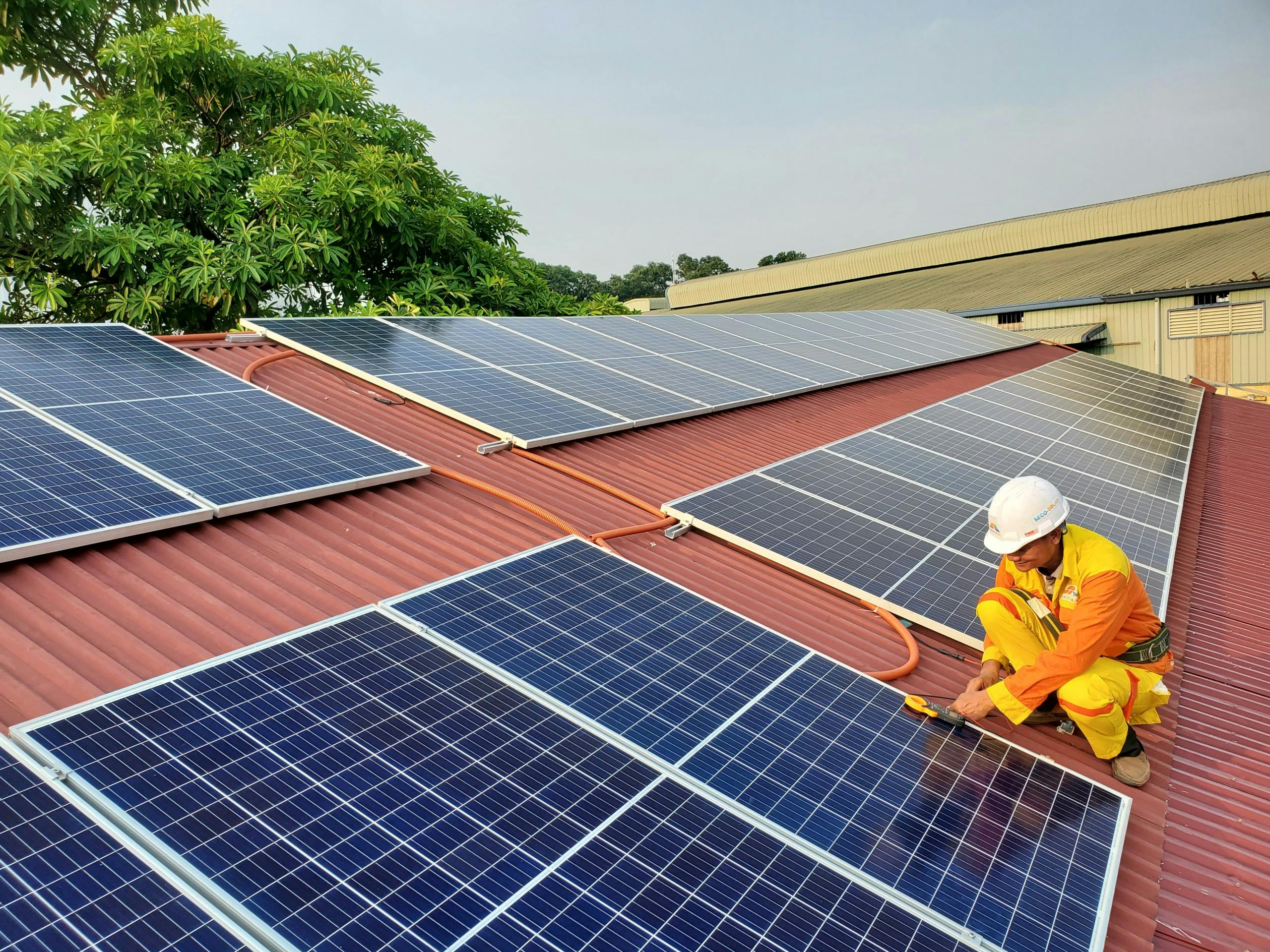 A construction worker installing solar panels on a rooftop