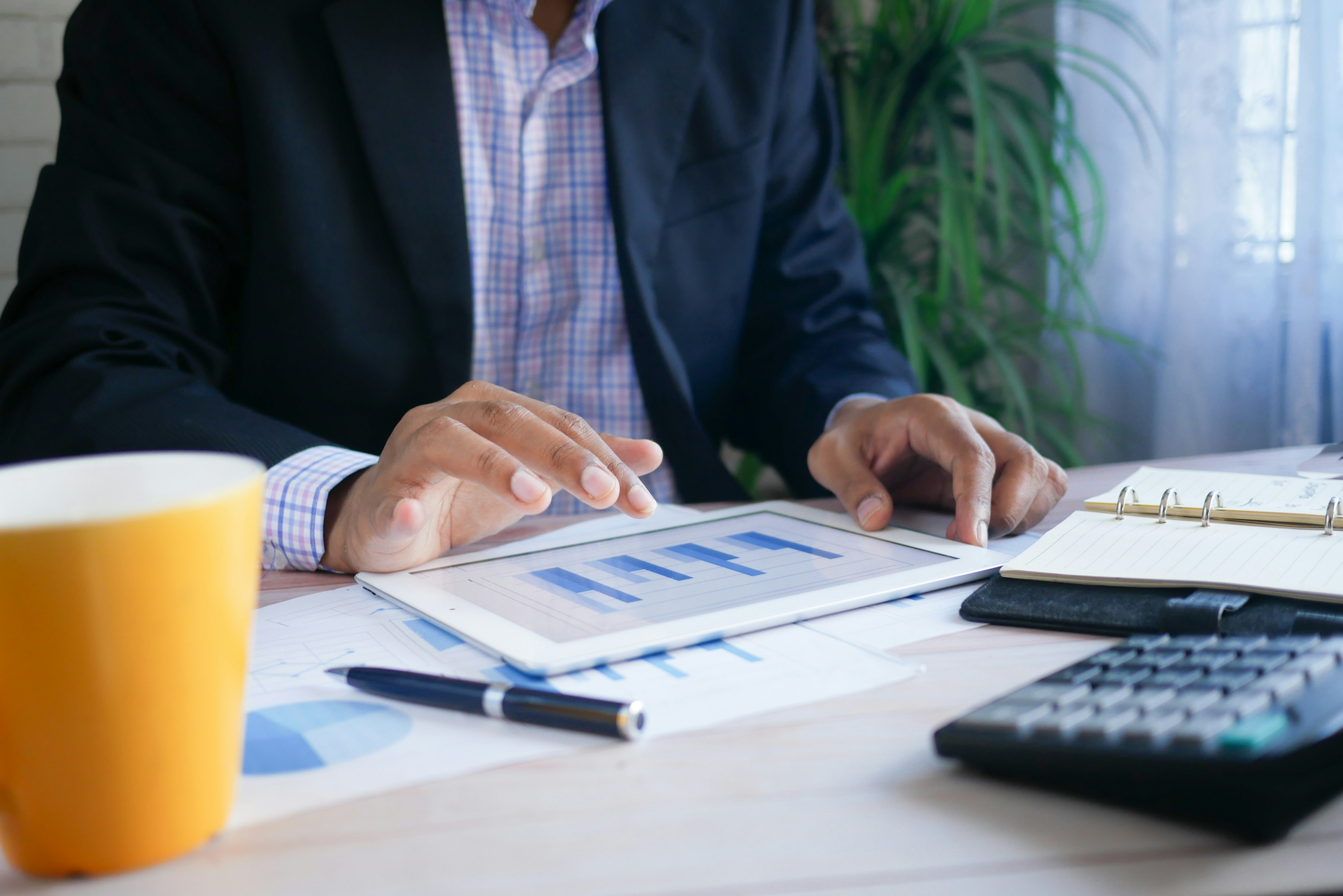 Man in suit looking at graphs on iPad