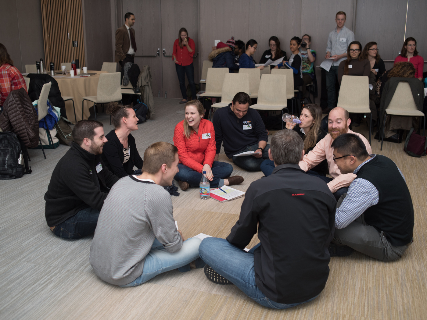 people sitting in a circle on the floor participating in the climate action simulation