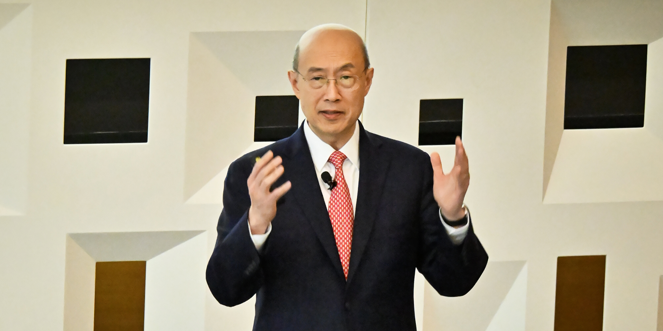 A person delivers a lecture to a crowded auditorium