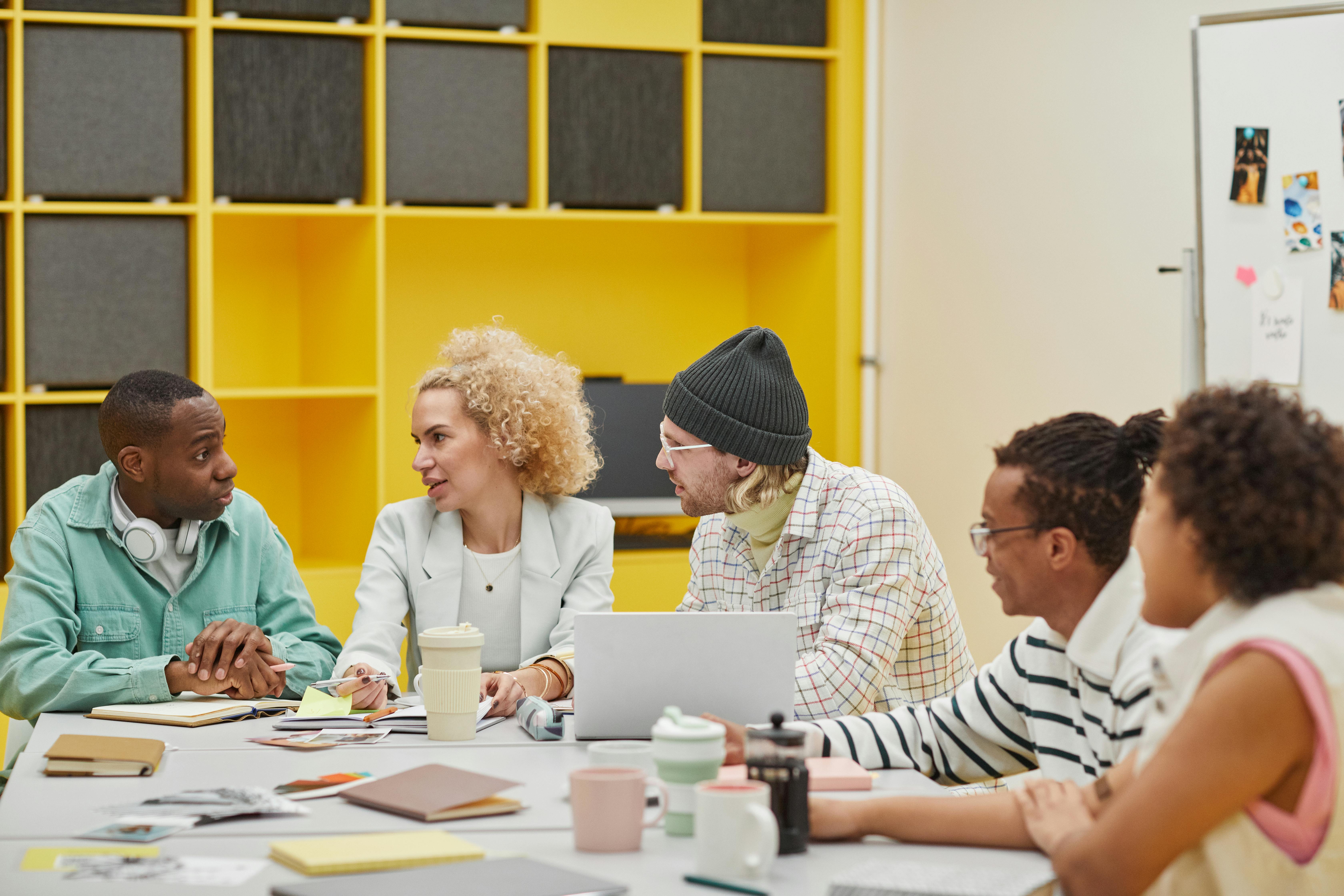 Image of five employees having a meeting at a table