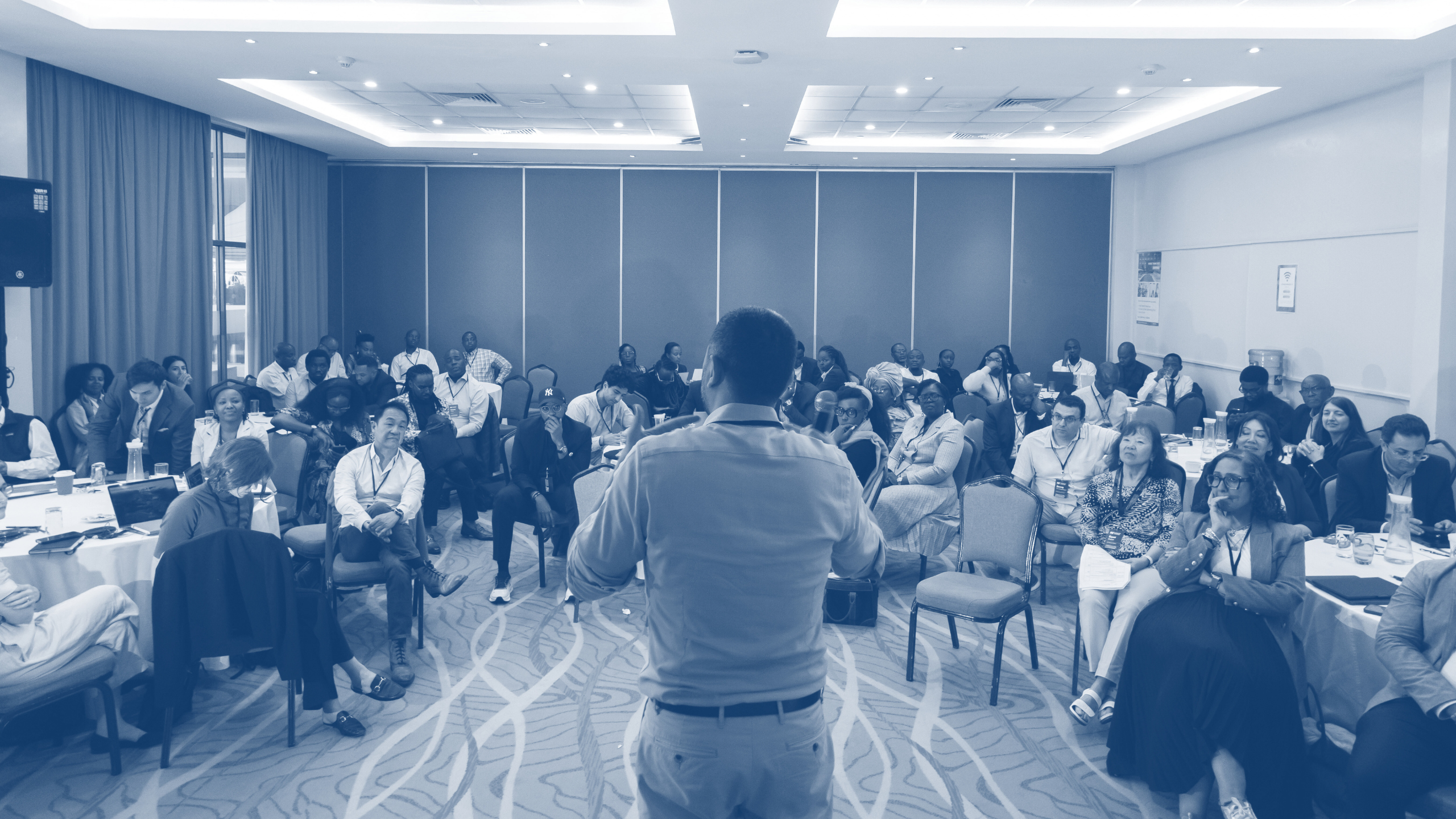 wide photo of a group gathered in meeting room