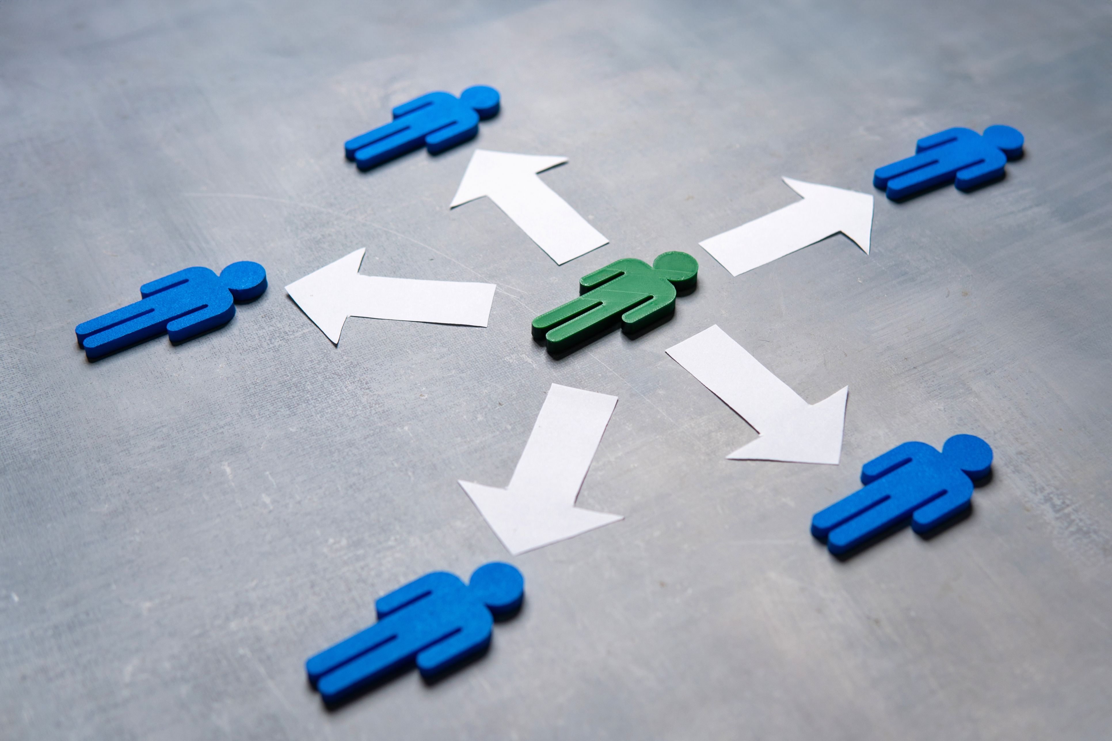 A green figure at the center surrounded by blue figures with arrows.