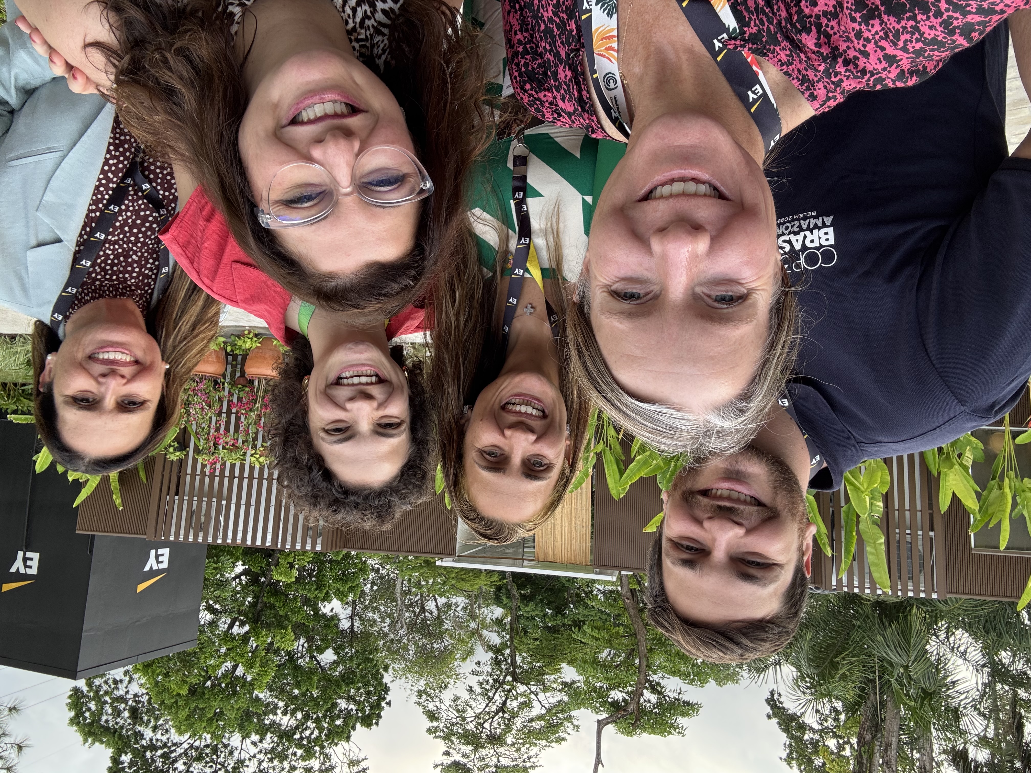 Group selfie of 6 smiling people outside.