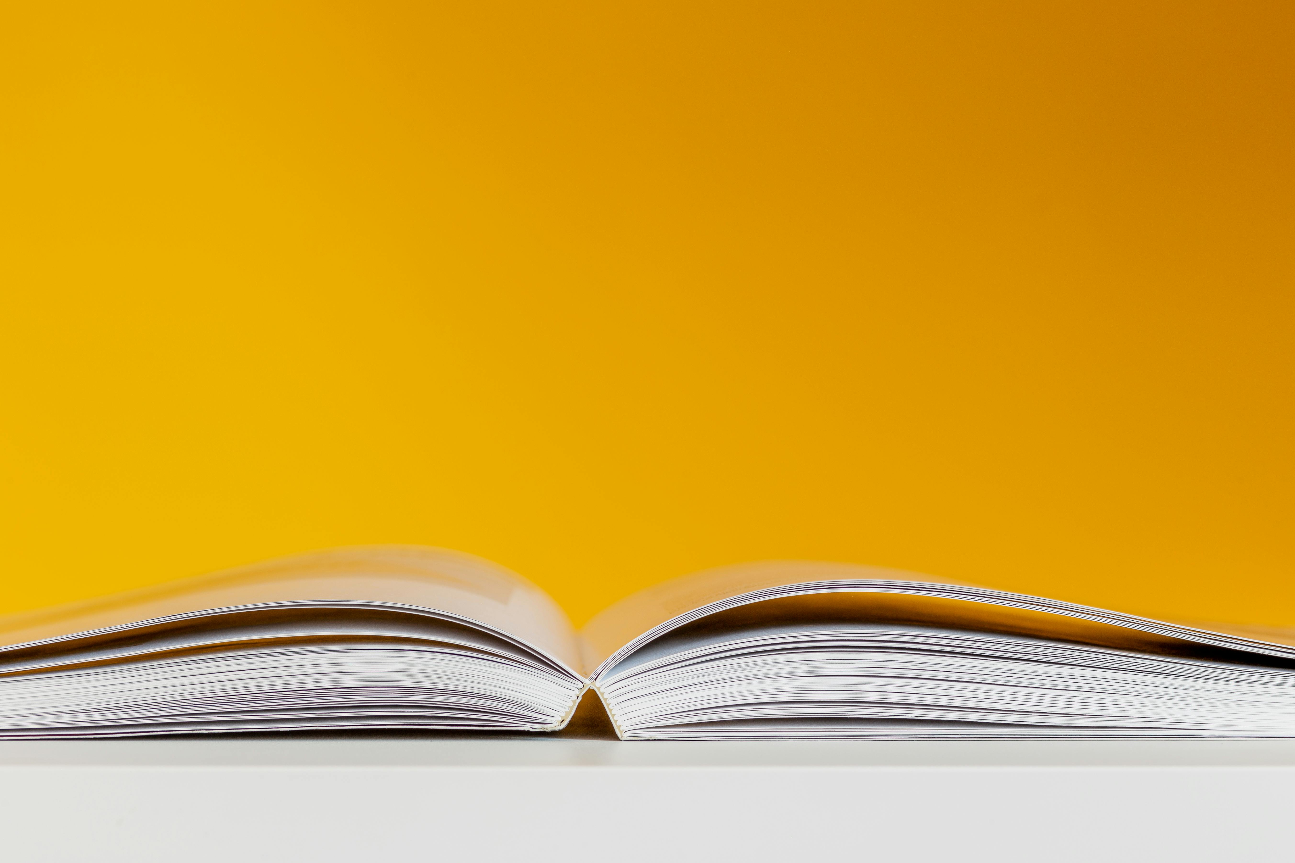 an open book on a yellow background