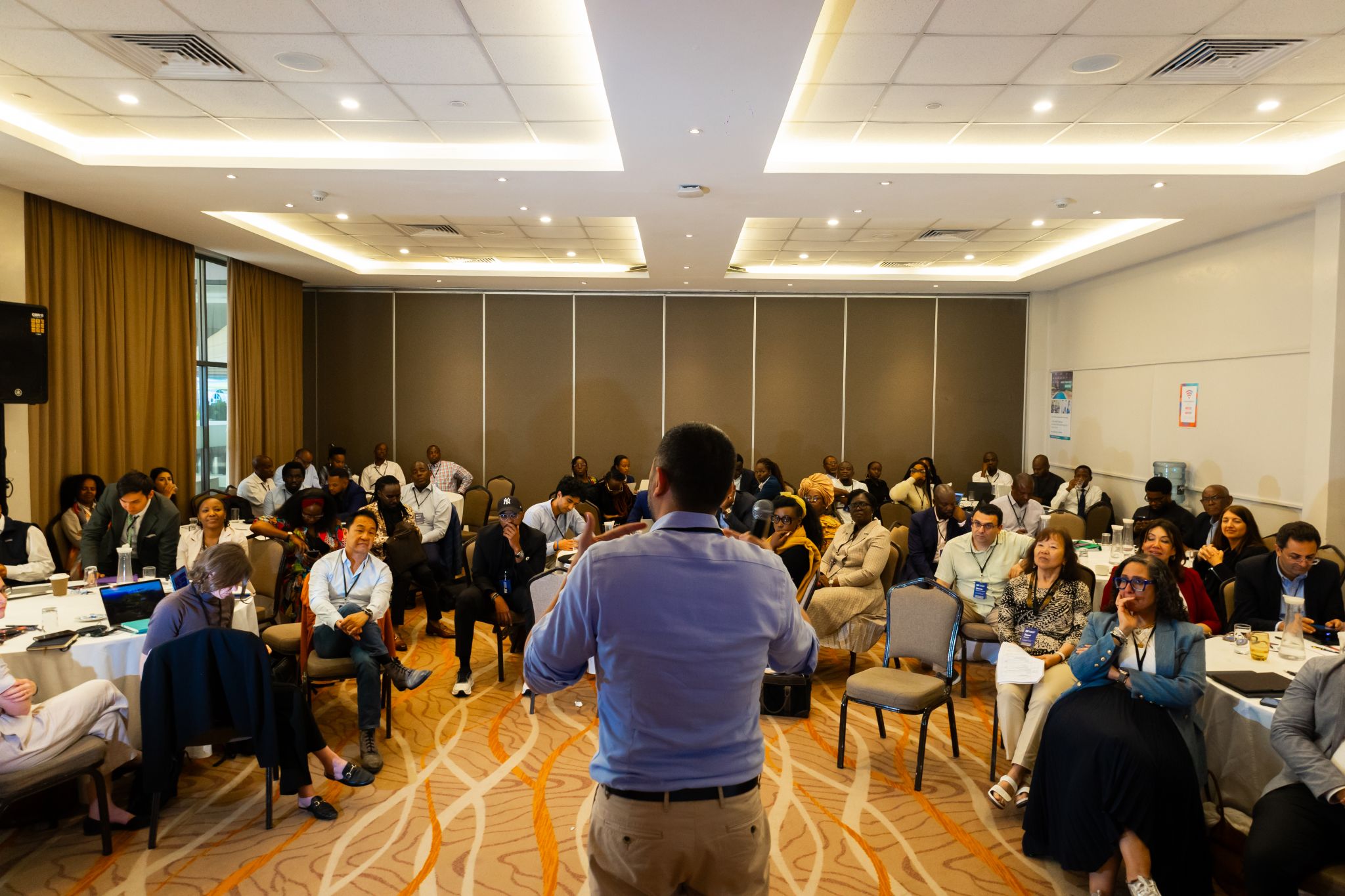 photograph of man speaking to a group of people
