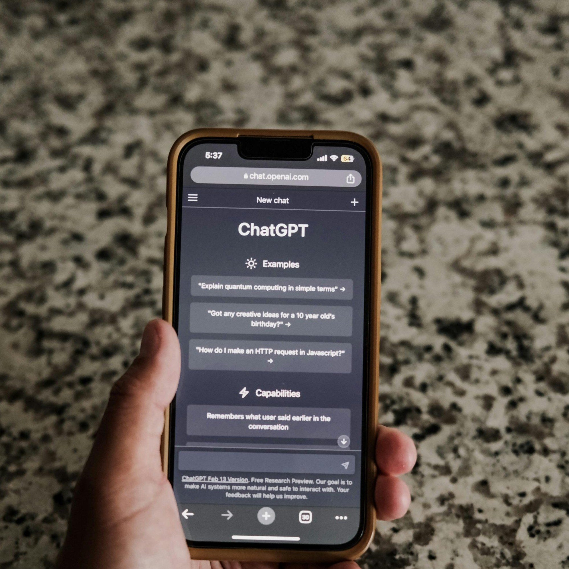 A hand holding a mobile phone that is open to ChatGPT