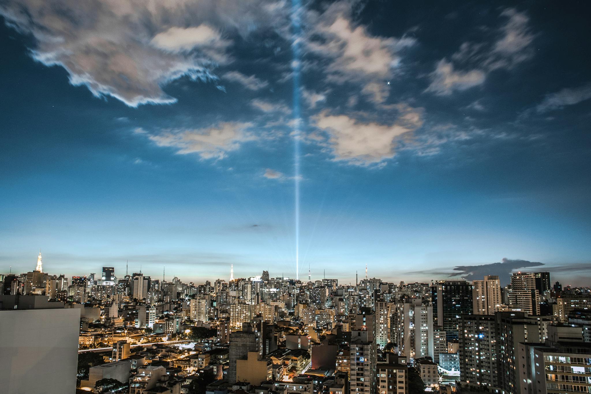 Sao Paolo, Brazil with lots of lights and a beam of light emitting straight into the sky