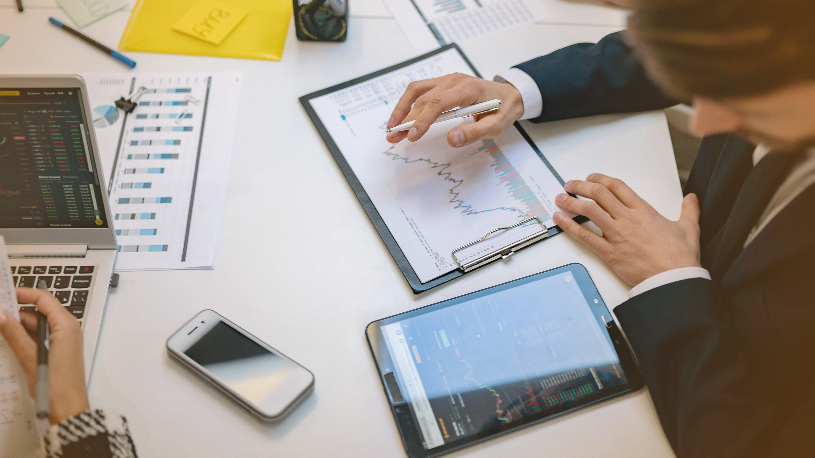 Investors looking at stock market charts on a table