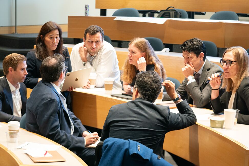 A group of students sitting in a circle working and discussing something.