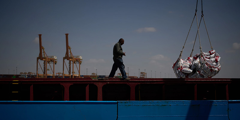 A worker walks on the deck of a feeder vessel as he works to offload cargo of rice into trucks at Umm Qasr Port, a deep-water port, in the city of Umm Qasr, Iraq, Friday, March 27, 2026.