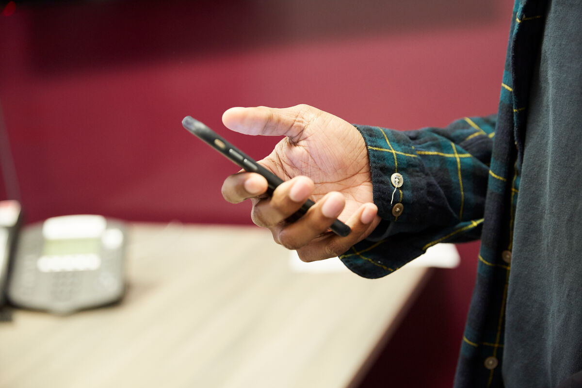 Photo of a person's hand holding a smartphone