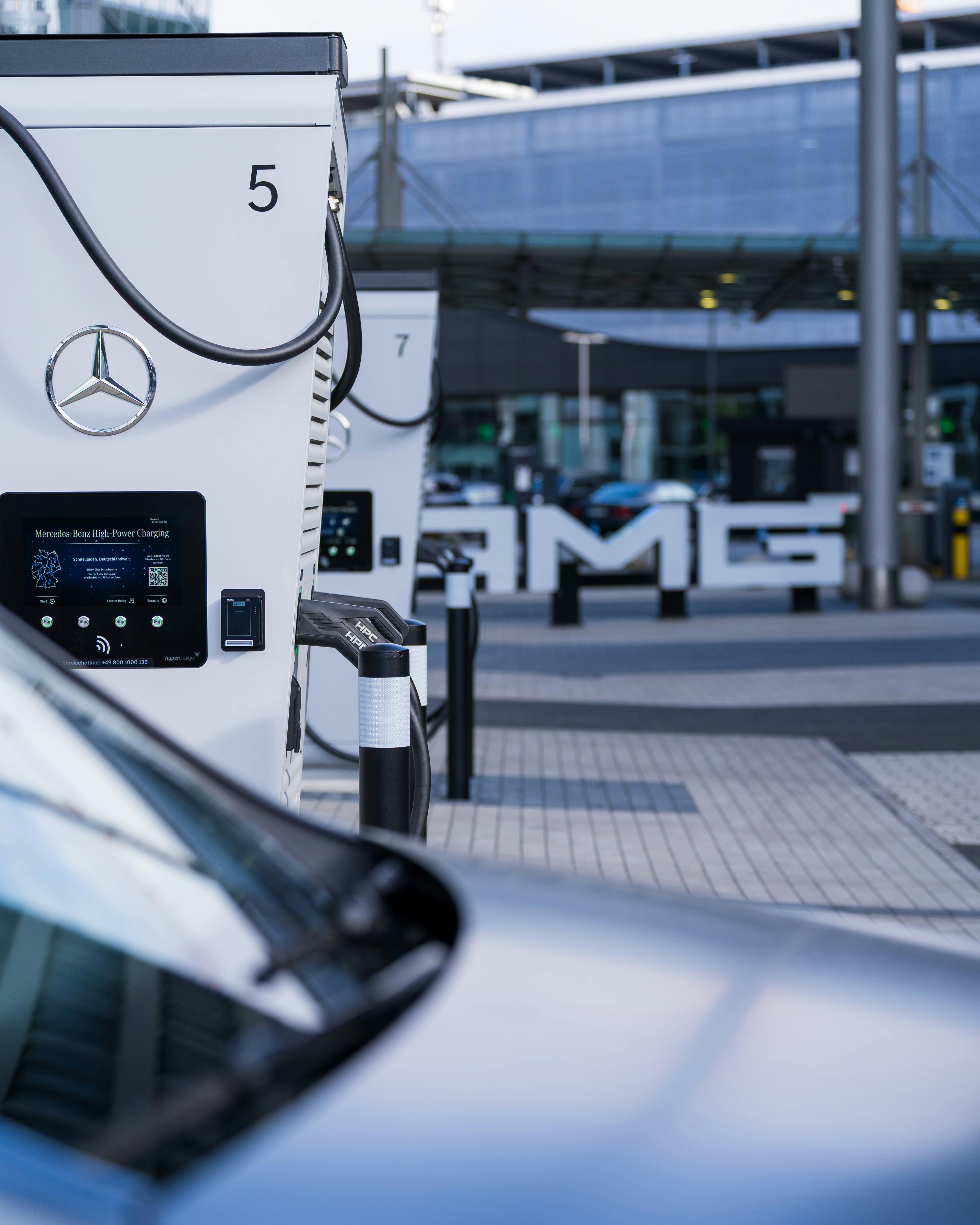 Contemporary electric vehicle charging station with Mercedes branding in a smart city setting.