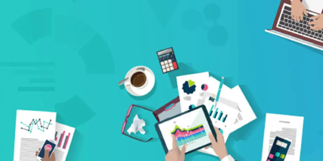 Hands working with laptops, documents and tablets on a blue background showing charts.