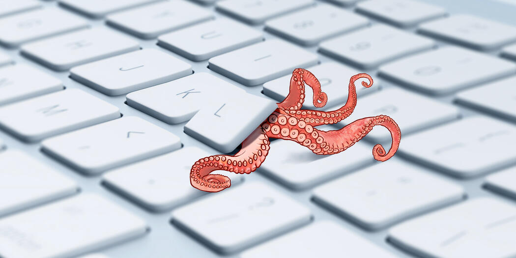 red octopus crawling out of an Apple keyboard