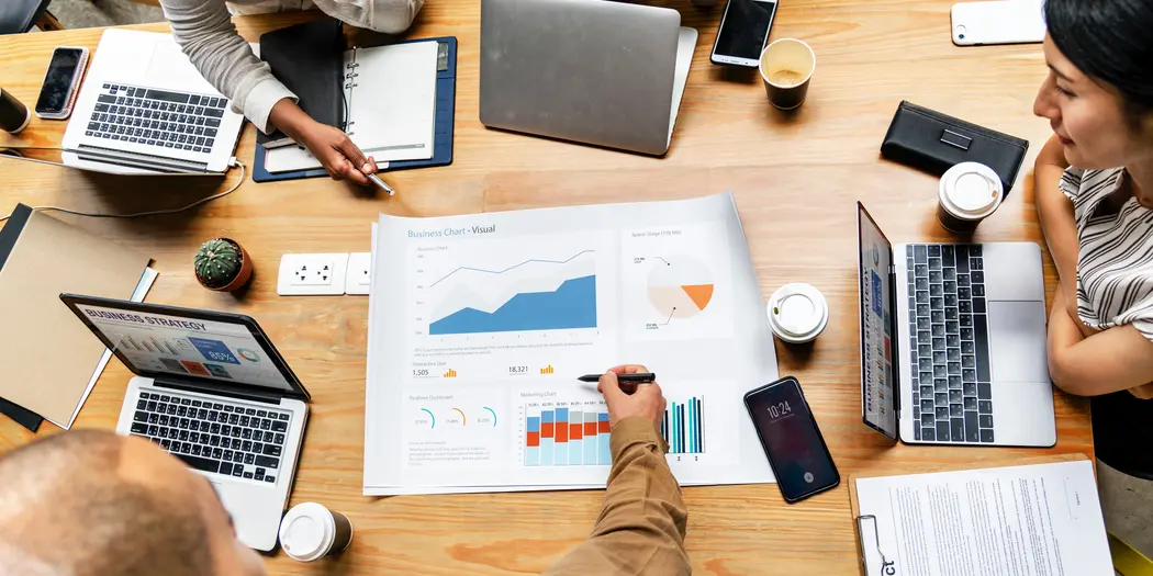 People discussing charts around table