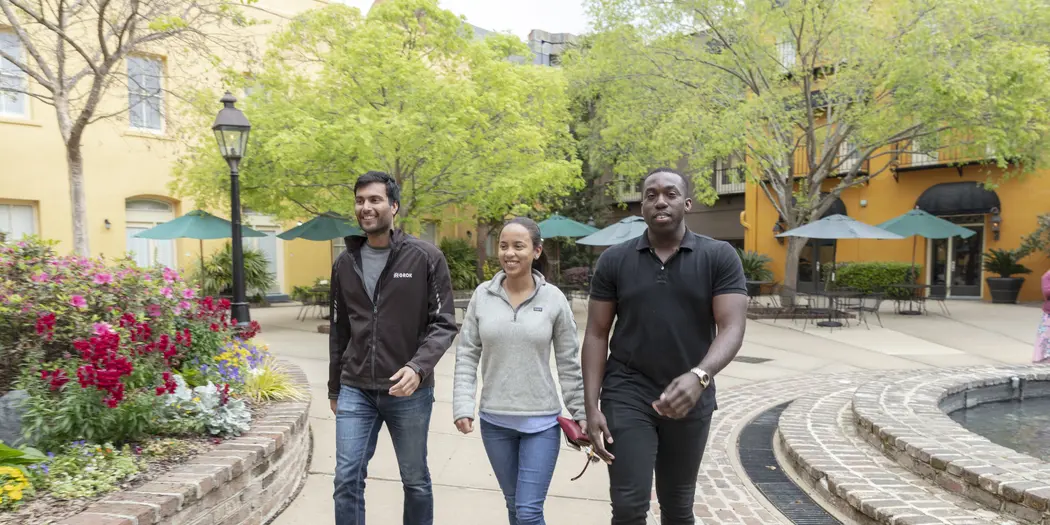 3 USA Lab students walking along a sidewalk in Charleston, SC. 
