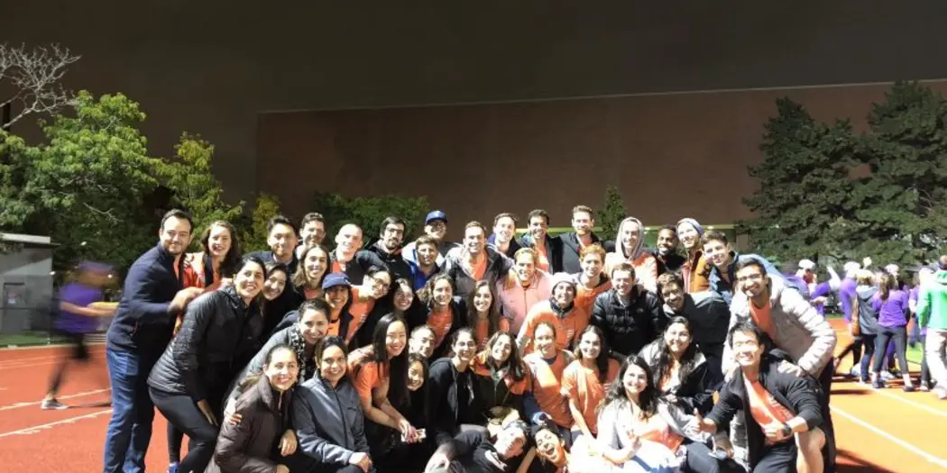 Group of MBA Students posing at a track field during Sloan Olympics.