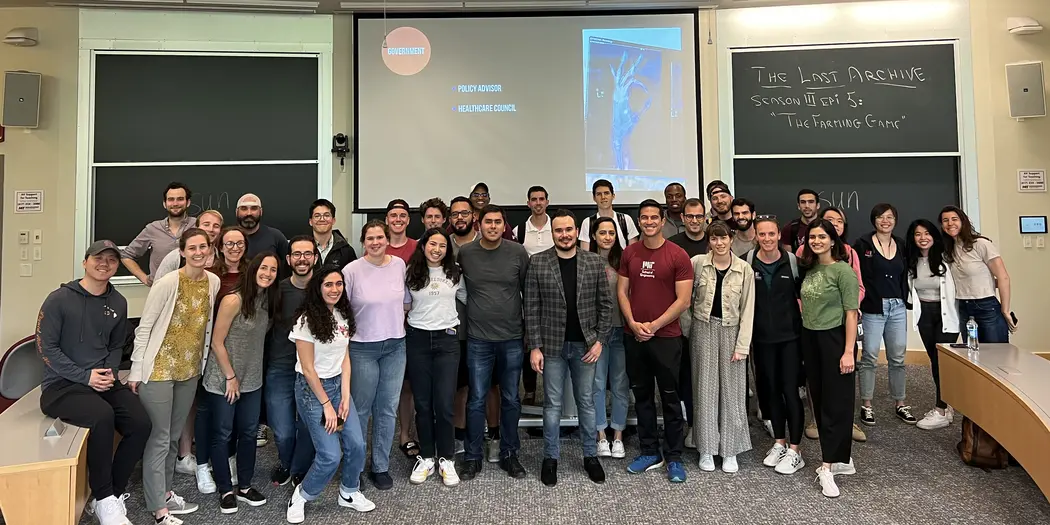 Group of students poses in front of a chalkboard in a classroom