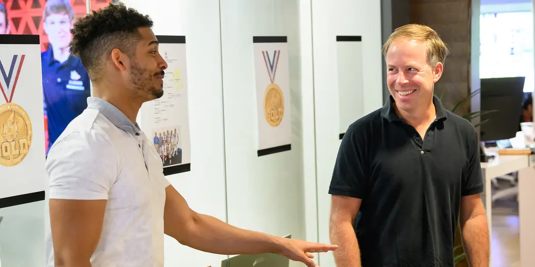 Two men smile while having a discussion