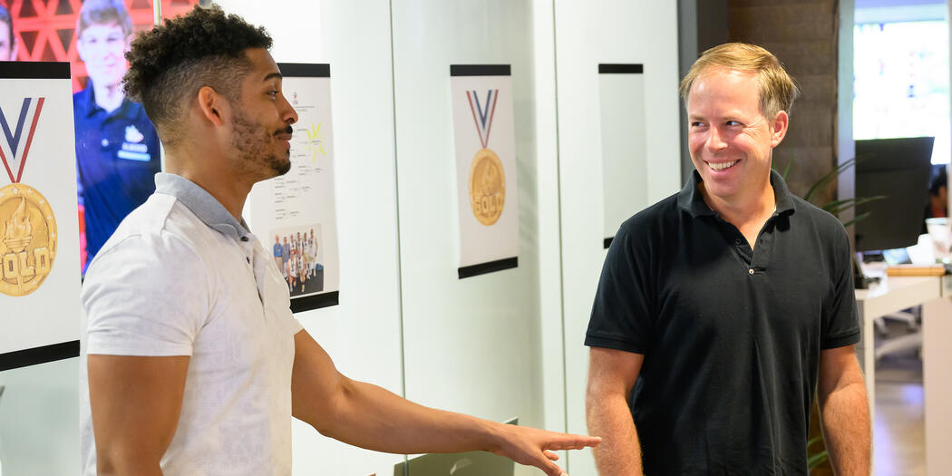 Two men smile while having a discussion