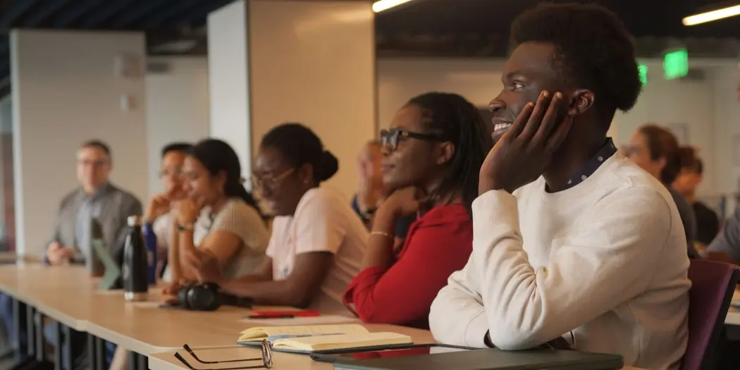 Group of students sitting at desk watching presentation