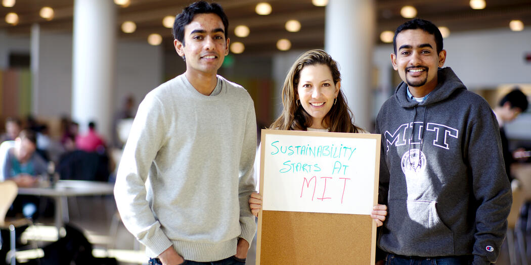 Three people holding a sign that says "Sustainability Starts at MIT"