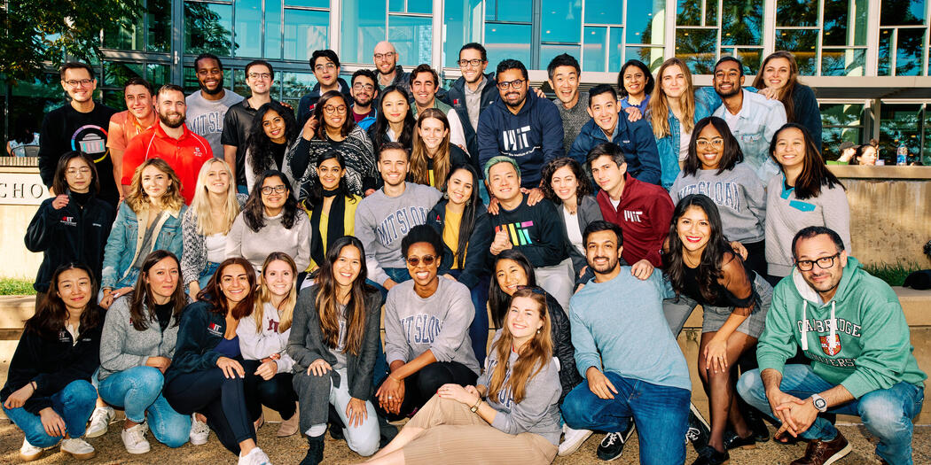 Members of MIT Sloan Student Senate sitting outside together on a sunny day.