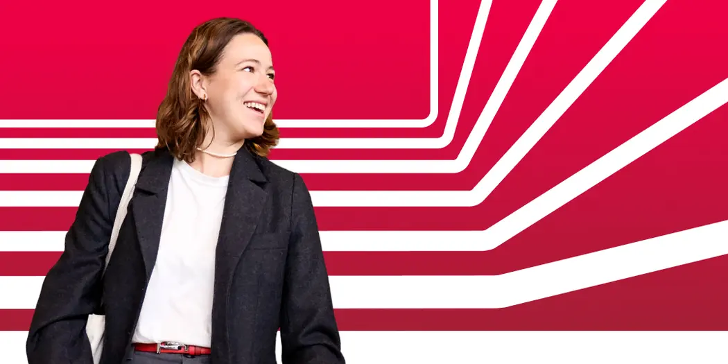 A student looks off camera, smiling, against a red background with white stripes