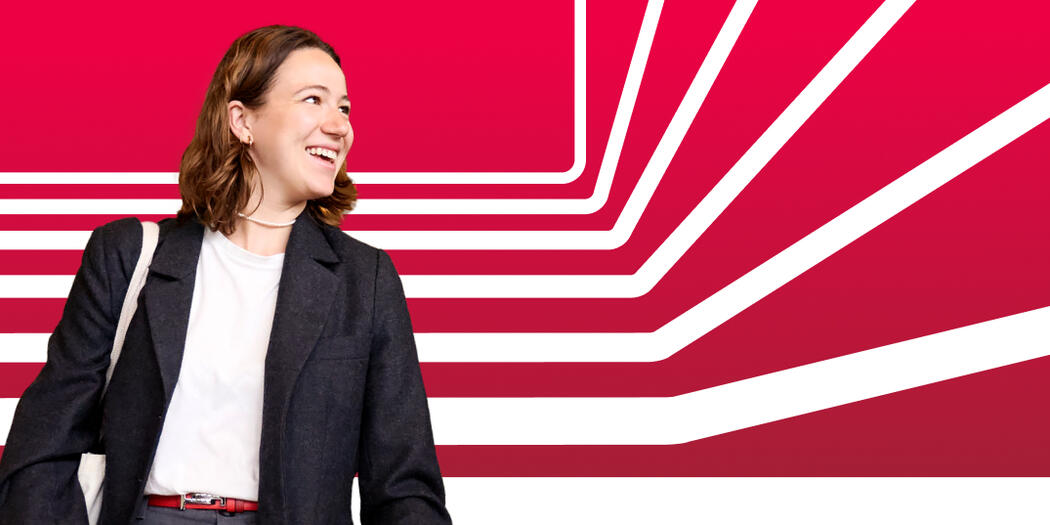 A student looks off camera, smiling, against a red background with white stripes
