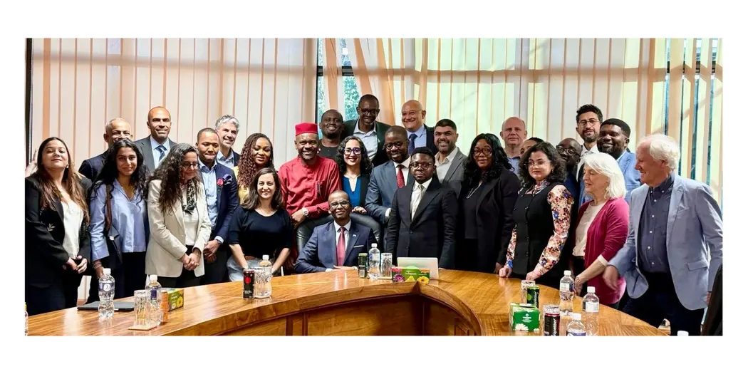 Group photo of people sitting and standing around a table