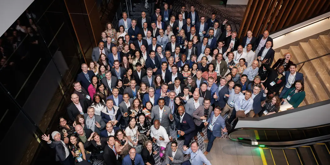 Large group of people pose for a photo at the base of some stairs