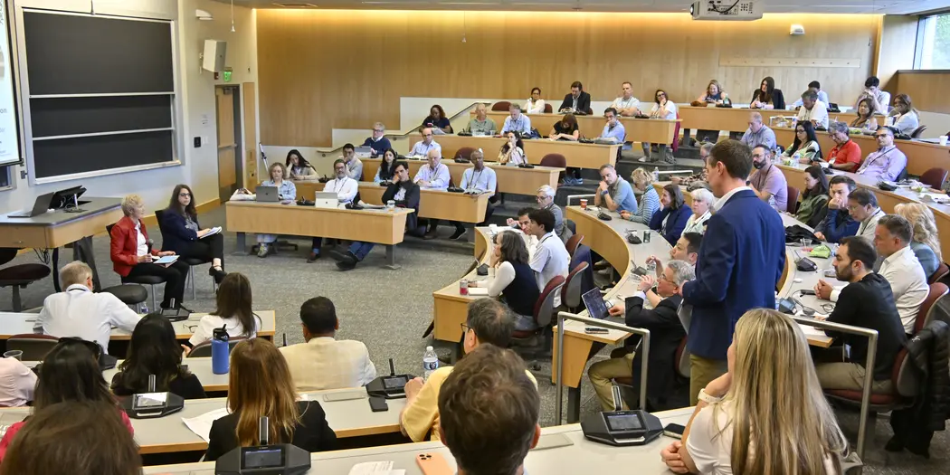 Classroom of people listen attentively to panelists.