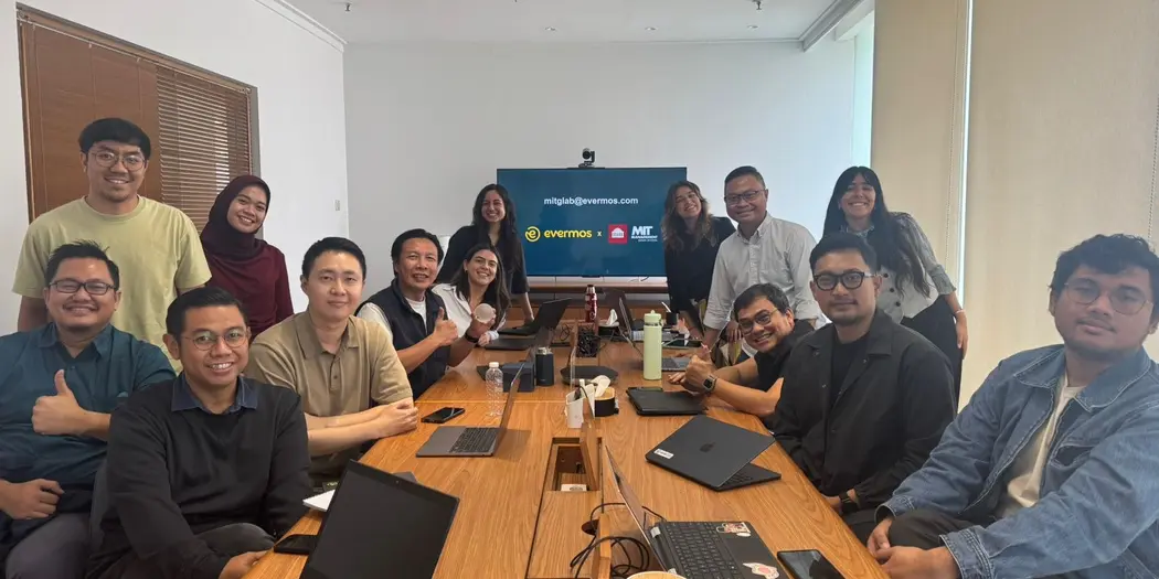 G-Lab students and hosts posing at a conference table in the Evermos office