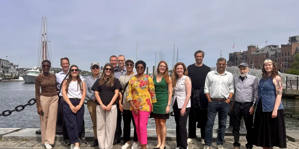 a group of people stand in front of Boston harbor