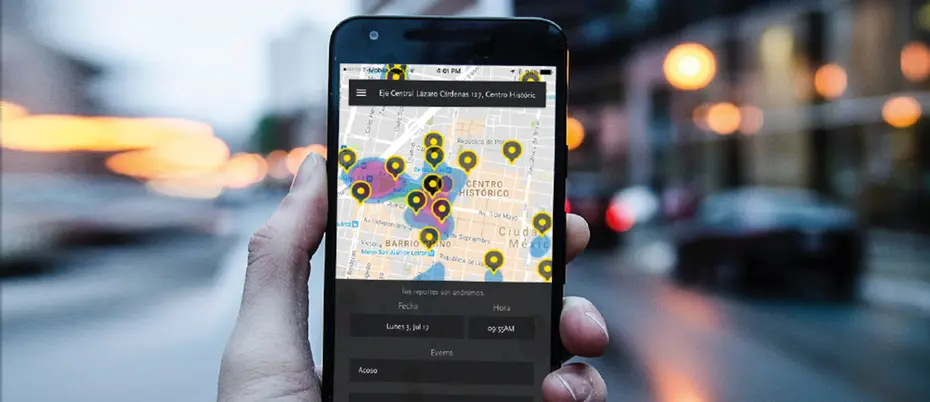 Hand holding phone with app by Base Operations open in front of city street