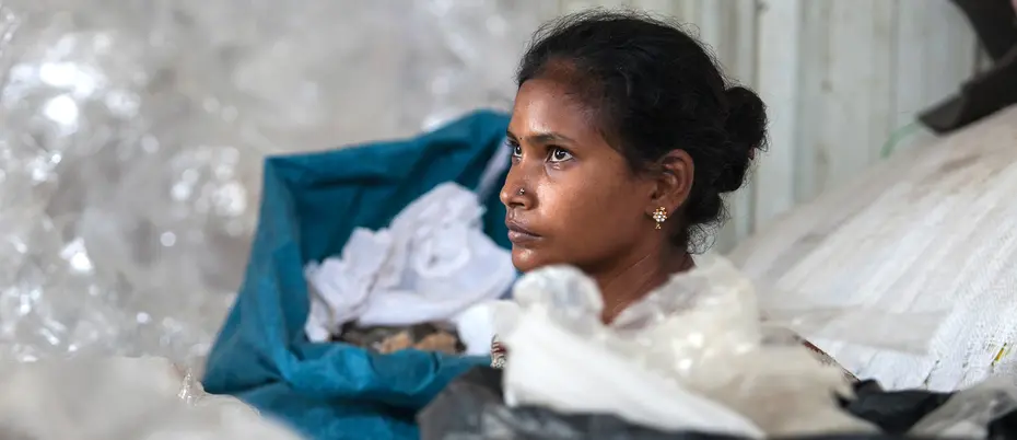Female worker collecting and sorting plastic urban waste