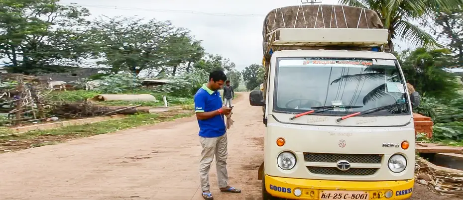 Driver uses logistimo app next to truck
