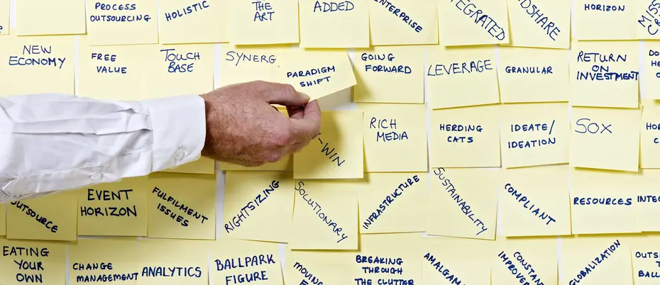 Arm picking up a post-it on a wall of them