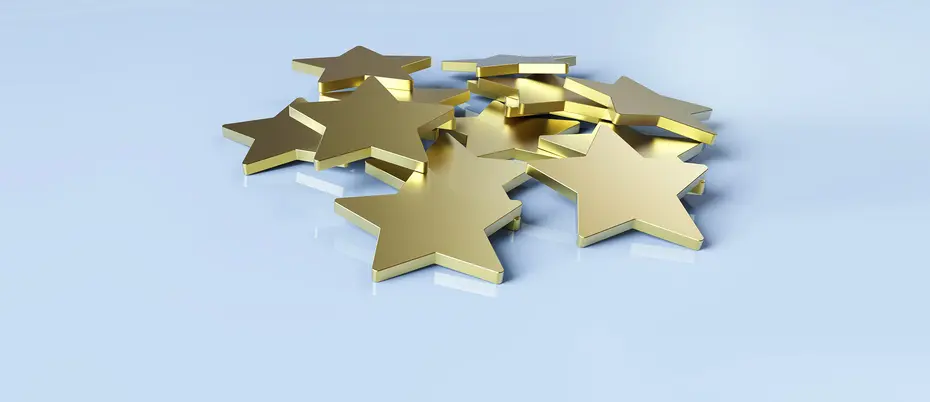 a pile of gold stars on a pale blue background