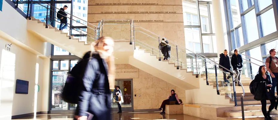 students walk through lobby with staircase