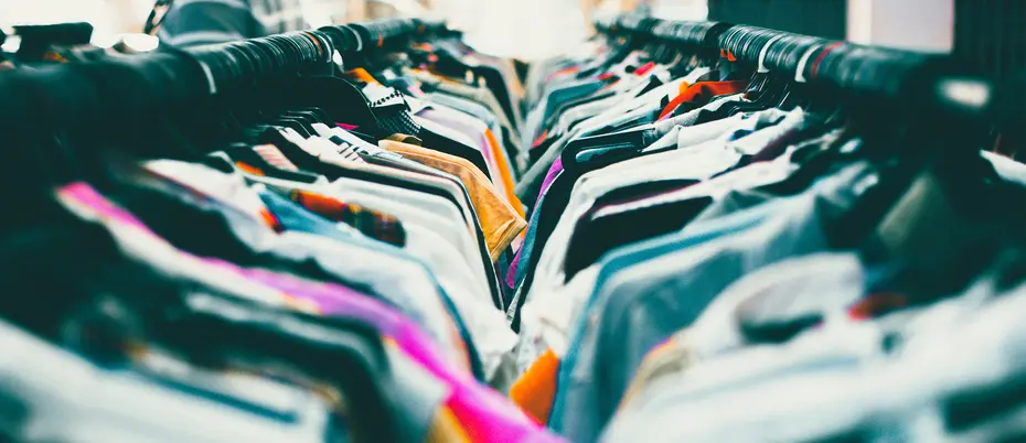 Two clothing racks crowded with shirts